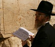 A man reads Psalms at the Western Wall
